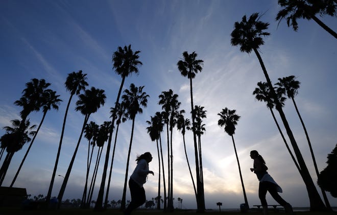 Women run as the sun sets in San Diego. File Photo/The Associated Press