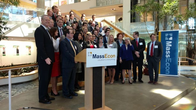 Gov. Charlie Baker, front left, poses with representatives of 18 global companies that have expanded to Massachusetts since the beginning of 2015.