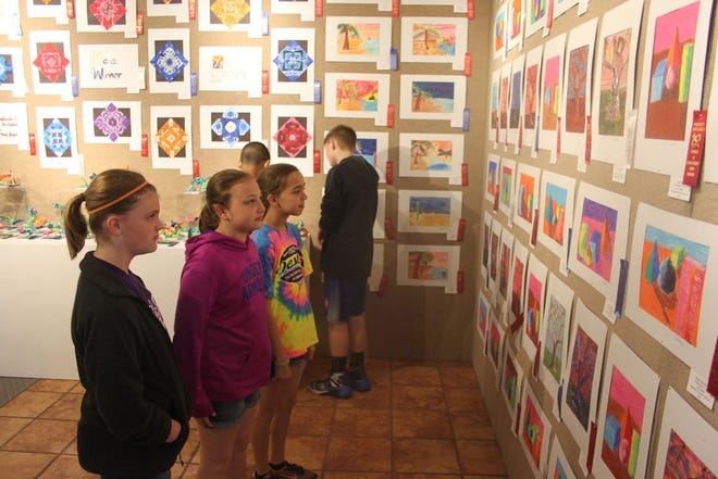 Three Central Intermediate fifth graders, McKinley Rexroat, Josie
Blake and Paige Richardson, admire art work created by their peers at
the Buchanan Center for the Arts Wednesday morning. Each year, the BCA
hosts the Town and Country Exhibition, to showcase the artistic
abilities of students from Warren, Henderson and Mercer counties.
