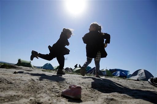 Children play in a makeshift camp at the northern Greek border point of Idomeni, Greece, Thursday, April 21, 2016. Many thousands of migrants remain at the Greek border with Macedonia, hoping that the border crossing will reopen, allowing them to move north into central Europe. (AP Photo/Gregorio Borgia)