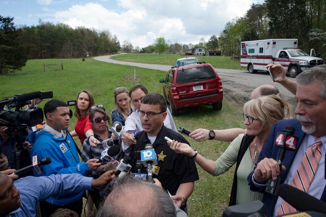 Lt. Michael Preston, of the Ross County Sheriff's Department speaks to the media on Union Hill Road that approaches a crime scene, Friday, April 22, 2016, in Pike County, Ohio. Shootings with multiple fatalities were reported along the road in rural Ohio on Friday morning, but details on the number of deaths and the whereabouts of the suspect or suspects weren't immediately clear. The attorney general's office said a dozen Bureau of Criminal Investigation agents had been called to Pike County, an economically struggling area in the Appalachian region some 80 miles east of Cincinnati. (AP Photo/John Minchillo)