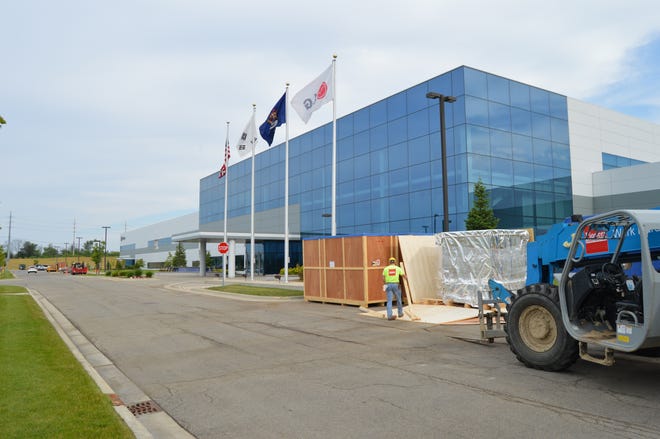 Workers uncrate production equipment at LG Chem Michigan, Inc. that will be part of the fourth line of production at the Holland campus during summer 2015. Sentinel file