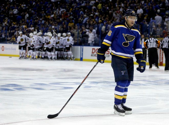 St. Louis Blues' Paul Stastny skates on the ice as members of the Chicago Blackhawks gather around teammate Patrick Kane in the background after he scored the game-winning goal during the second overtime in Game 5 of an NHL hockey first-round Stanley Cup playoff series early Friday, April 22, 2016, in St. Louis. The Blackhawks won 4-3.