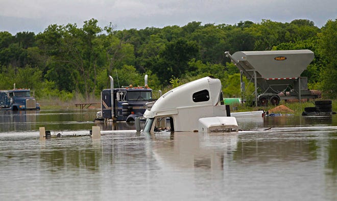 Trucks at a repair shop in Texas Highway 114 are flooded as Lake Bridgeport continues to rise with runoff from recent rains, in Bridgeport, Texas, Wednesday, April 20, 2016. The death toll has reached several in Southeast Texas flooding after storms dumped more than a foot of rain. (Rodger Mallison/Star-Telegram via AP) MANDATORY CREDIT