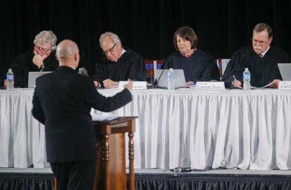 Kansas Supreme Court justices take notes while listening to oral arguments from Dustin Van Dyk, an attorney for the Keiswetter estate, during a hearing in the Topeka High auditorium last month.