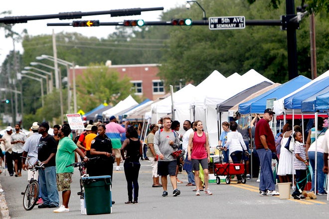 Visitors walk along NW 6th Street during the 36th annual 5th Avenue Arts Festival on Saturday, April 25, 2015.