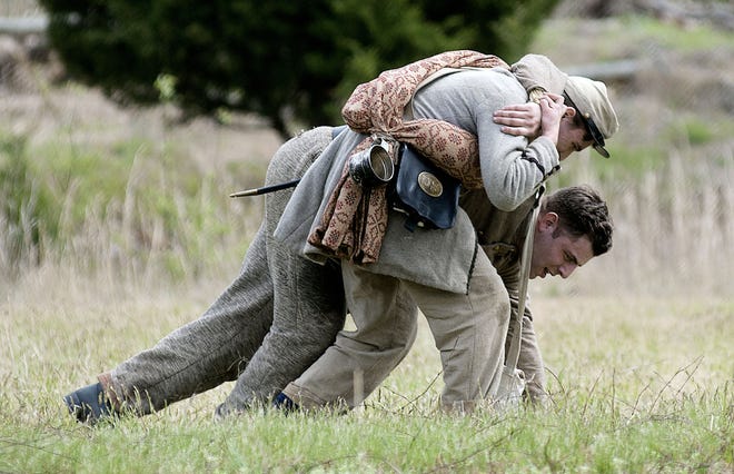 A wounded Confederate soldier is helped off the battle field Saturday, April 23, 2016, during the Civil War re-enactment of the First Battle of Bull Run/Battle of First Manassas at Neshaminy State Park in Bensalem. The battle continues Sunday in the park.