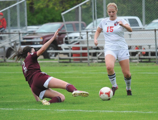 Pekin's Riley Cascia avoids a sliding IVC defender during Friday's game opening game of the Pekin Soccer Invitational.