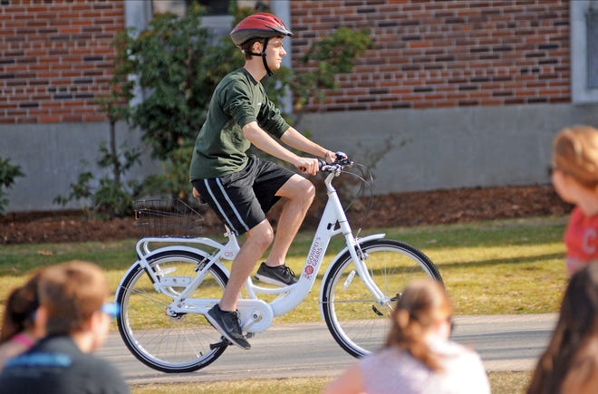 WPI student Ryan Cooney, the president of WPI's environmental club called the Green Team, takes one of the new WPI bike share program bikes out for a spin Thursday. T&G Staff/Steve Lanava