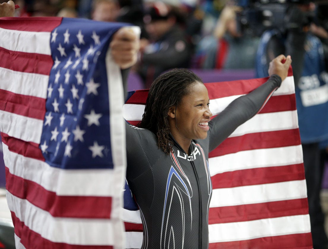 Lauryn Williams holds the flag after winning a silver medal in the women's bobsled competition at the 2014 Winter Olympics in Krasnaya Polyana, Russia.