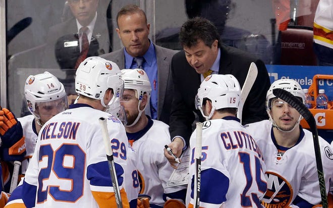 New York Islanders coach Jack Capuano goes through play with the players during a timeout in the third period of Game 1 in a first-round NHL hockey Stanley Cup playoff series against the Florida Panthers, Thursday, April 14, 2016, in Sunrise, Fla. The Islanders won 5-4. (AP Photo/Alan Diaz)
