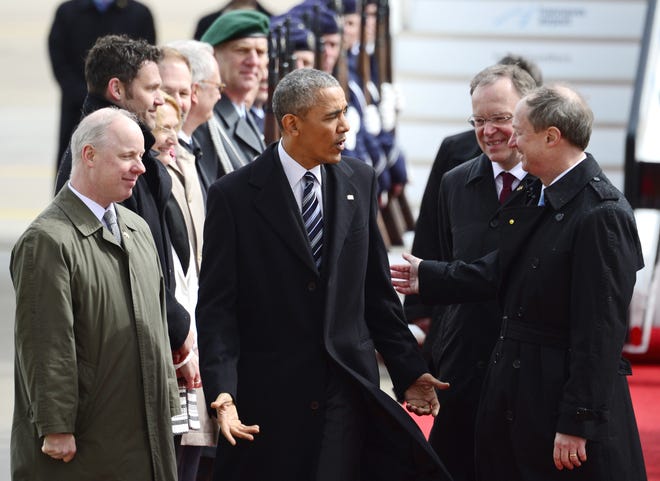 U.S. President Barack Obama, center, talks to John B. Emerson, US ambassador to Germany, right, and Stephan Weil, governor of German state of Lower Saxony, second right, upon his arrival at the airport in Hannover, northern Germany, Sunday, April 24, 2016. Obama is on a two-day official visit to Germany. (AP Photo/Jens Meyer)