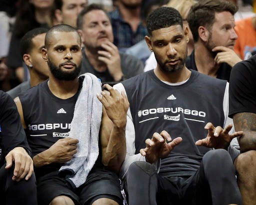 San Antonio Spurs guard Patty Mills, left, plays air guitar and center Tim Duncan, right, joins in on the keyboards as they play along with music from the arena loudspeakers during a timeout in the second half of Game 4 in a first-round NBA basketball playoff series against the Memphis Grizzlies, Sunday, April 24, 2016, in Memphis, Tenn. (AP Photo/Mark Humphrey)