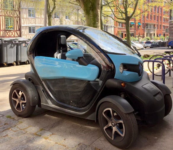 A Renault Twizy in Rouen, France. This plug-in (rechargeable) electric two-seat urban runabout, also sold by Nissan as the New Mobility Concept, costs less than $10,000; the battery pack is leased for a small monthly fee that includes roadside assistance and a replacement guarantee. (Silvio Calabi)