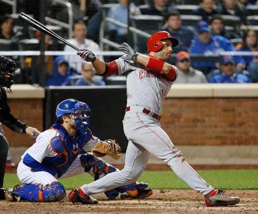 New York Mets catcher Travis d'Arnaud, left, watches as Cincinnati Reds Joey Votto (19) hits a game-tying, seventh-inning, RBI single in a baseball game Monday, April 25, 2016, in New York. (AP Photo/Kathy Willens)