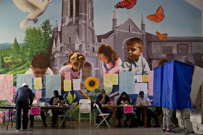 Poll workers sit next to electronic voting machines at the Francis Myers Recreation Center polling location in Philadelphia on April 26. (Bloomberg photo by Andrew Harrer)