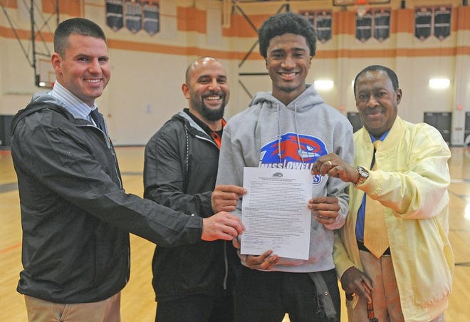 Taunton High track star Brian Cherenfant holds up his letter of intent with dad Gaston, right and Tiger coaches Jeff Moore, left and Jason Torres.