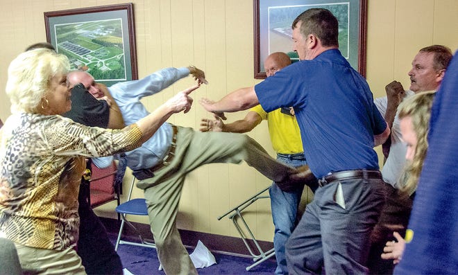 Alexander City Mayor Charles Shaw, left, is restrained by an officer after a fight broke out between him and councilman Tony Goss, far right, during a City Council meeting on Monday. Those attending the meeting along with officers had to intervene after the meeting adjourned. The meeting was intended to discuss city audits and other municipal financial issues but the meeting broke down to a shouting match before it ended and the brawl ensued.
