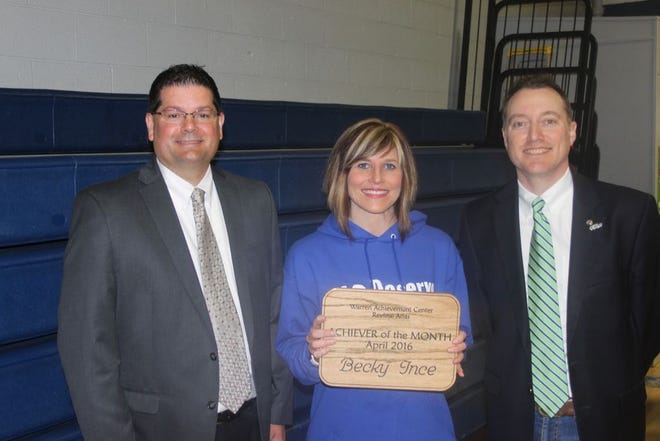 Warren Achievement Center President/CEO Rick Barnhill (left) and WAC Marketing Coordinator Sean Cavanaugh give Central Intermediate Principal Becky Ince the Achiever of the Month Award during a school assembly Wednesday morning.