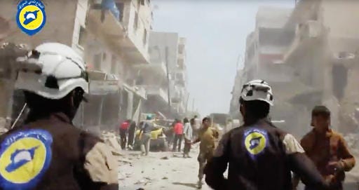 FILE - In this Sunday, April 24, 2016, file photo made from video posted online by the Syrian Civil Defense White Helmets, Civil Defense workers run after airstrikes and shelling hit Aleppo, Syria. A military buildup in northern Syria coupled with heavy fighting and mounting civilian casualties spells the end of a cease-fire that for two months brought much needed relief to war-stricken Syrians, ushering in what could be an even more ruinous chapter in the country's five-year-old conflict. (Syrian Civil Defense White Helmets via AP video, File)