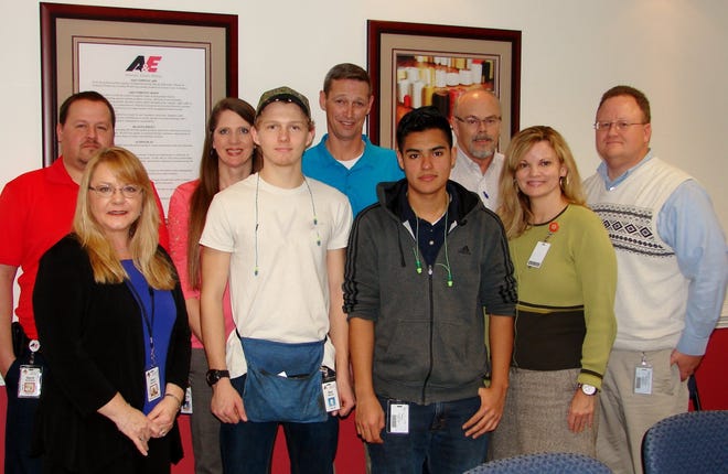 Forestview students Alex Hillsman and David Aviles, front and center, pose for a group photo with employees of American & Efird and Gaston County Schools. The two students are working part time at the industrial textile company for pay and class credit. COURTESY OF HEATHER FORBES