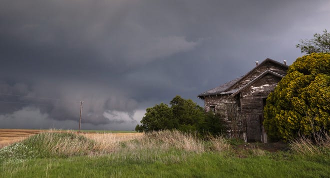 Storm clouds hang in the sky near Wellington, Kan., Tuesday, April 26, 2016. Thunderstorms bearing hail as big as grapefruit and winds approaching hurricane strength lashed portions of the Great Plains on Tuesday. (Travis Heying/The Wichita Eagle via AP)
