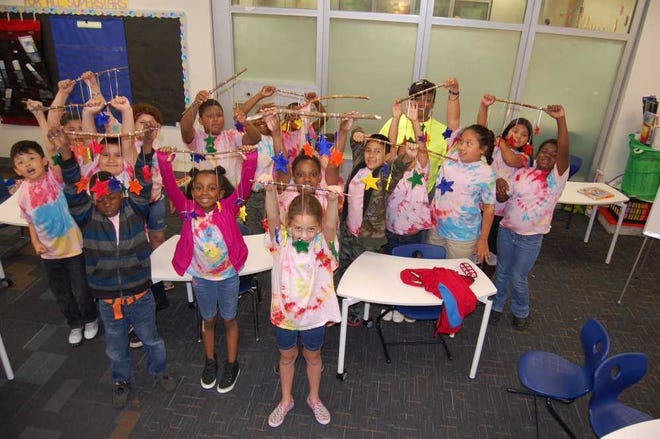 Third grade students at Stroud Elementary School show off the colorful mobiles they made to give to the less fortunate during the school's annual Day of Service Friday. In the back is Stroud principal Marsha Thomas, subbing for an absent teacher. (Lee Shearer/Staff)