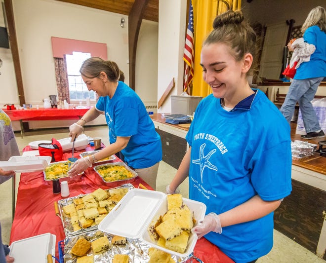 Louise and Annmarie Bernardi serve cornbread at the Youth StreetReach breakfast on Saturday. PHOTO BY ALAN BELANICH