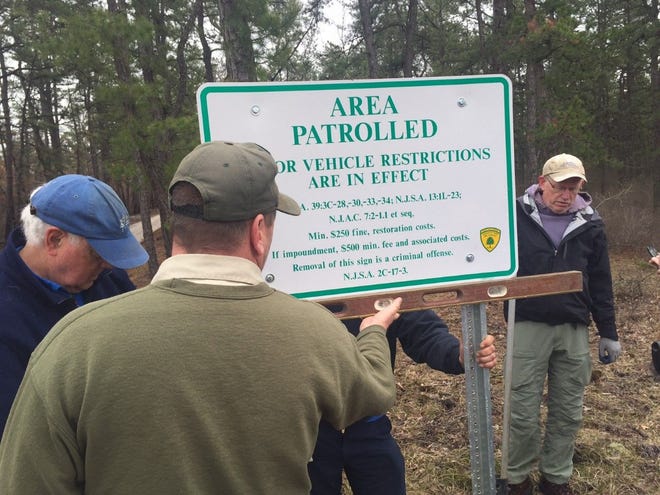 (File) Volunteers from environment and recreation groups help post signs in Wharton State Forest on Friday, April 29, 2016, that warn against illegal off-road vehicle activity.