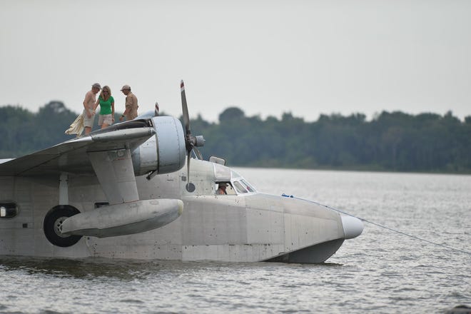 People stand on top of an HU-16 Albatross moored off the dock in Wooton Park in Tavares, during a seaplane fly-in last May.