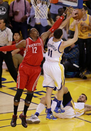Golden State Warriors' Klay Thompson, right, and Houston Rockets' Dwight Howard, left, reach for a rebound during the first half in Game 5 of a first-round NBA basketball playoff series Wednesday, April 27, 2016, in Oakland, Calif. (AP Photo/Ben Margot)