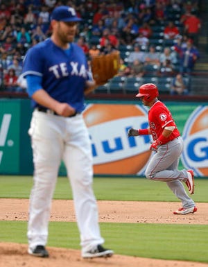 Texas Rangers starting pitcher Colby Lewis (48) stands on the mound as Los Angeles Angels' Geovany Soto rounds the bases following his solo home run off of Lewis during the third inning of a baseball game, Friday, April 29, 2016, in Arlington, Texas. (AP Photo/Tony Gutierrez)