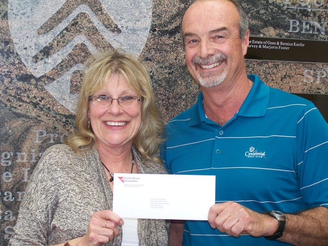 Monte Mendenhall, Pacific Power Regional Business Manager for Jackson and Siskiyou counties, presents a $2,500 check from The Pacific Power Foundation to Susan Ikenberry, development director for Fairchild Medical Center Foundation, for the free mammogram program at FMC.