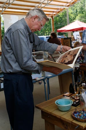 Harold Bigham, of Taylorville, Ala., looks through a vintage calendar at the booth of Red Barn Antiques, based in Gordo, Ala., while browsing various tables at the Vintage Market, Sunday May 4, 2014 in downtown Northport, Ala. near Kentuck Park.
The Tuscaloosa News | Erin Nelson