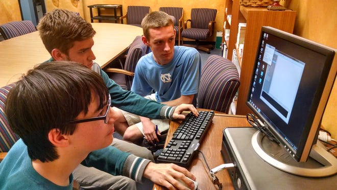 From left, Highland School of Technology students Benjamin Blackwell, Jack Helm and James Stewart use the computer software that they spent the past three months designing and coding. Their project took first place in the state at the North Carolina Technology Student Association State Conference in Greensboro earlier this month. (The Gazette/Eric Wildstein)