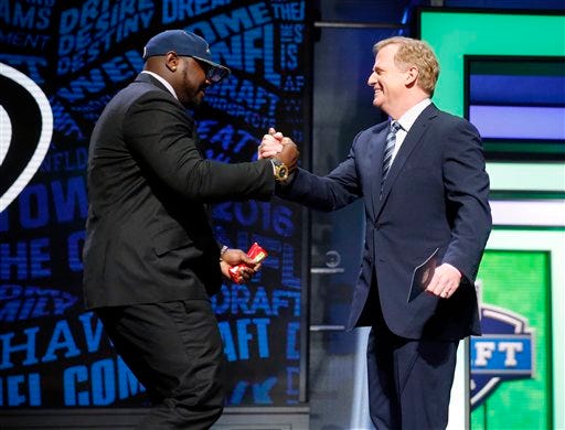 Alabama’s Jarran Reed celebrates with NFL Commissioner Roger Goodell after being selected by the Seattle Seahawks as the 49th pick in the second round of the 2016 NFL football draft, Friday, April 29, 2016, in Chicago. (AP Photo/Charles Rex Arbogast)