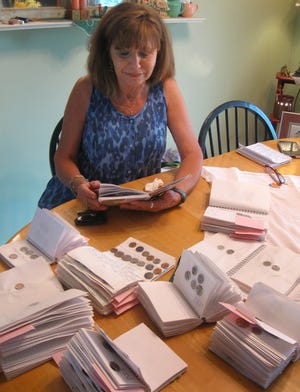 Jeanne Fulton of Ashland looks over some of her notebooks containing coins she has found in Ashland along with notes written about them in her Ashland home on Wednesday, April 27, 2016. Dave Bakke/The State Journal-Register