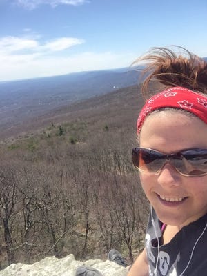Town of Shawangunk resident Karen Bayer smiles for a photo on top of Sam's Point Saturday, April 23, shortly before a fire broke out that burned at 2,028 acres of the 5,000-acre preserve. Photo provided