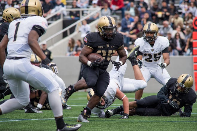 Fullback Aaron Kemper breaks through the defense during the Army Black-Gold spring football game at Michie Stadium in West Point on Saturday. Kemper scored Black's first touchdown on a 5-yard run. Kelly Marsh/For the Times Herald-Record