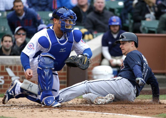Atlanta's Kelly Johnson scores on a sacrifice fly by Jace Peterson as Chicago catcher Tim Federowicz waits for the ball in the fifth inning. Johnson also drove in a run Sunday.