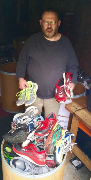 Jerry Hudgins, of Topeka, holds two pairs of shoes that have been donated.