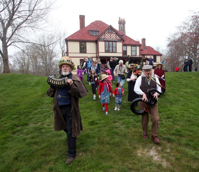 The Village Band leads the way to start of the Maypole celebration at Highfield Hall in Falmouth on Sunday. Ron Geering, left, played the concertina and Wendell Bishop was on the serpent. Steve Haines/Cape Cod Times