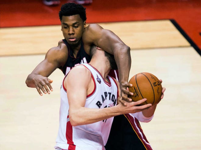 Miami's Hassan Whiteside (top) fouls Toronto's Jonas Valanciunas in the second half of Tuesday's game. The Heat won the Eastern Conference semifinal opener.