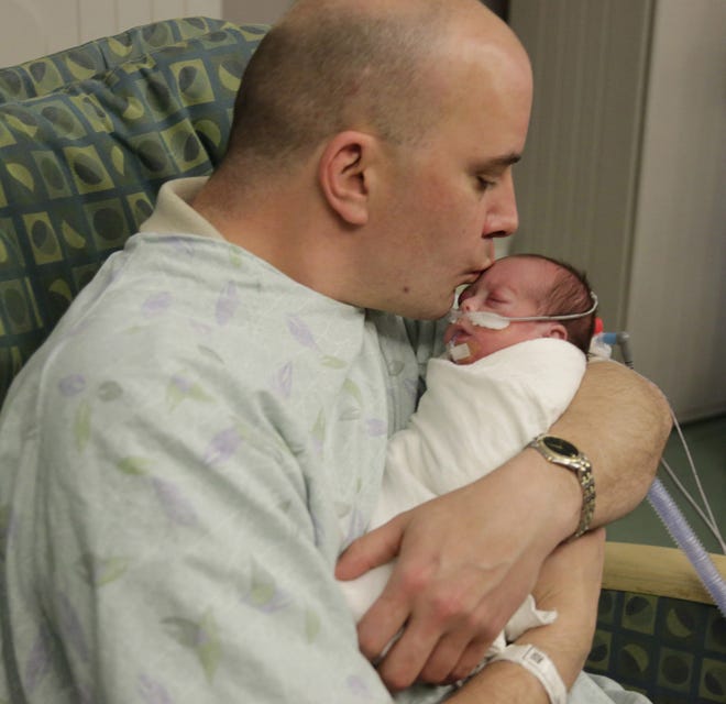 In this Tuesday, March 15 photo, parent Bryan Niedermeyer holds Evelyn, one of his twin preemie daughters after they underwent eye exams at Advocate Children's Hospital in Chicago. (AP Photo/M. Spencer Green)