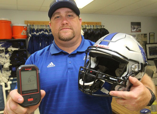 Matanzas High School head football coach Robert Ripley displays a Riddell football helmet equipped with an impact monitoring system and hand-held monitor at Matanzas High School in Palm Coast on Wednesday. NEWS-JOURNAL/DAVID TUCKER