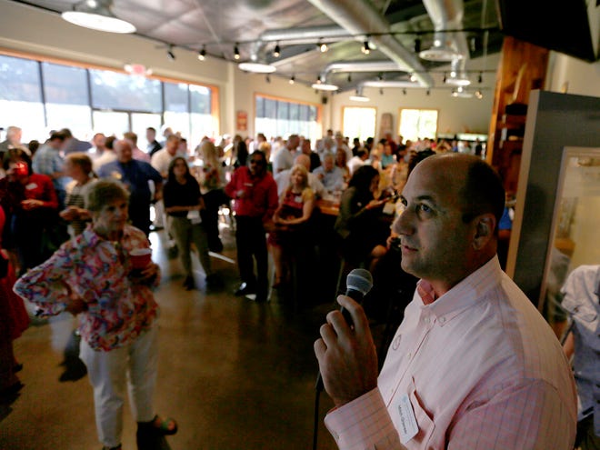 Mitch Glaeser reads the total amount raised to the crowd during the Amazing Give event at Swamp Head on Tuesday.