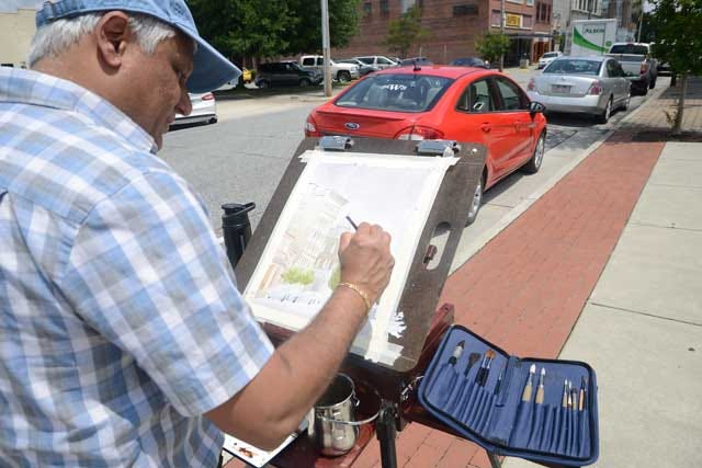 Tesh Parekh, of Raleigh, paints a street view of Gordon Street on Wednesday for the BBQ Festival on the Neuse Plein Art Paint Out competition.