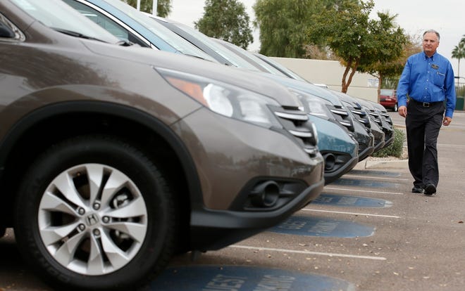 — AP file photo

Mike Johnson, a sales manager at a Honda dealership, walks past a row of CRVs in Tempe, Ariz.