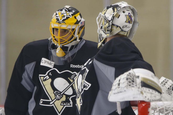Pittsburgh Penguins goalie Marc-Andre Fleury, left, talks with goalie Jeff Zatkoff during a practice session for the NHL hockey playoffs against the New York Rangers, Monday, April 11, 2016, at their practice facility in Cranberry Township. (AP Photo/Keith Srakocic)