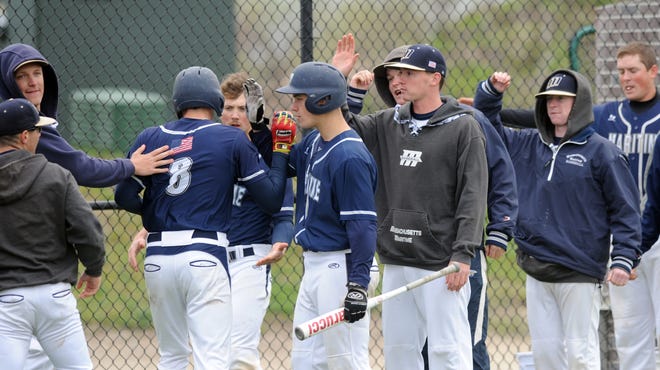 Connor Kennedy (8) of West Barnstate, a St. John Paul II graduate, is welcomed by his Massachusetts Maritime teammates after scoring the game's second run against Fitchburg State in Friday's state tournament game in Buzzards Bay. Ron Schloerb/Cape Cod Times